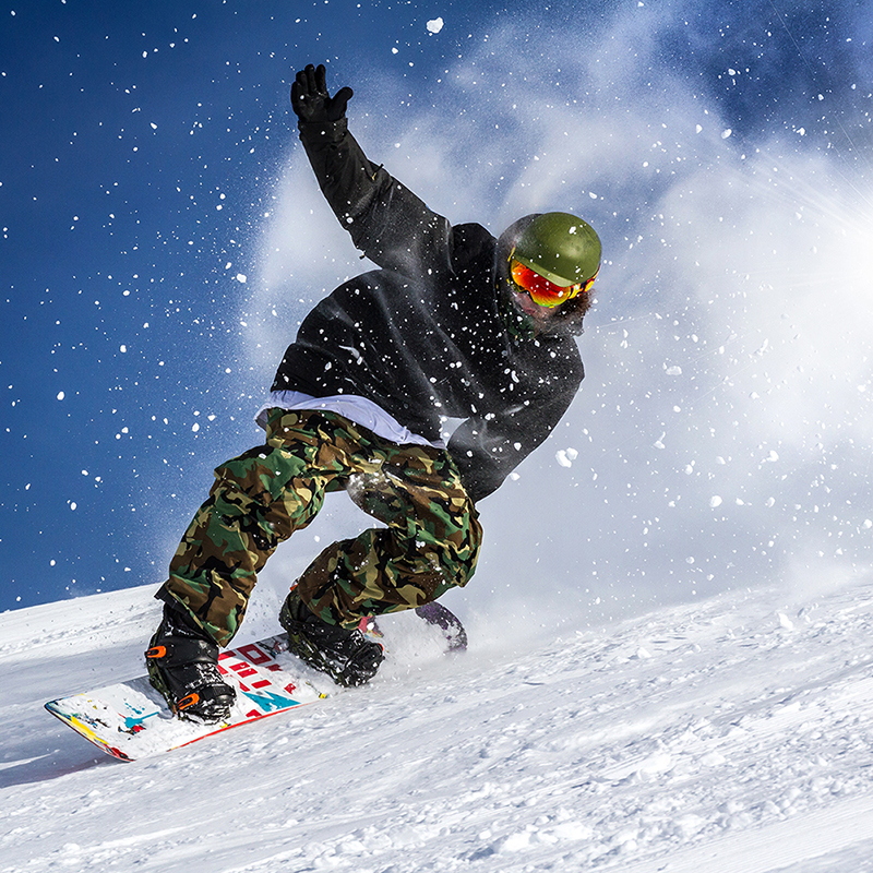 Snowboarder in action, representing the 'Freedom to Travel' with confidence thanks to comprehensive sports cover in travel insurance.